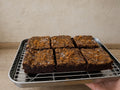 Six Miso Biscoff brownies arranged on a stainless-steel tray.