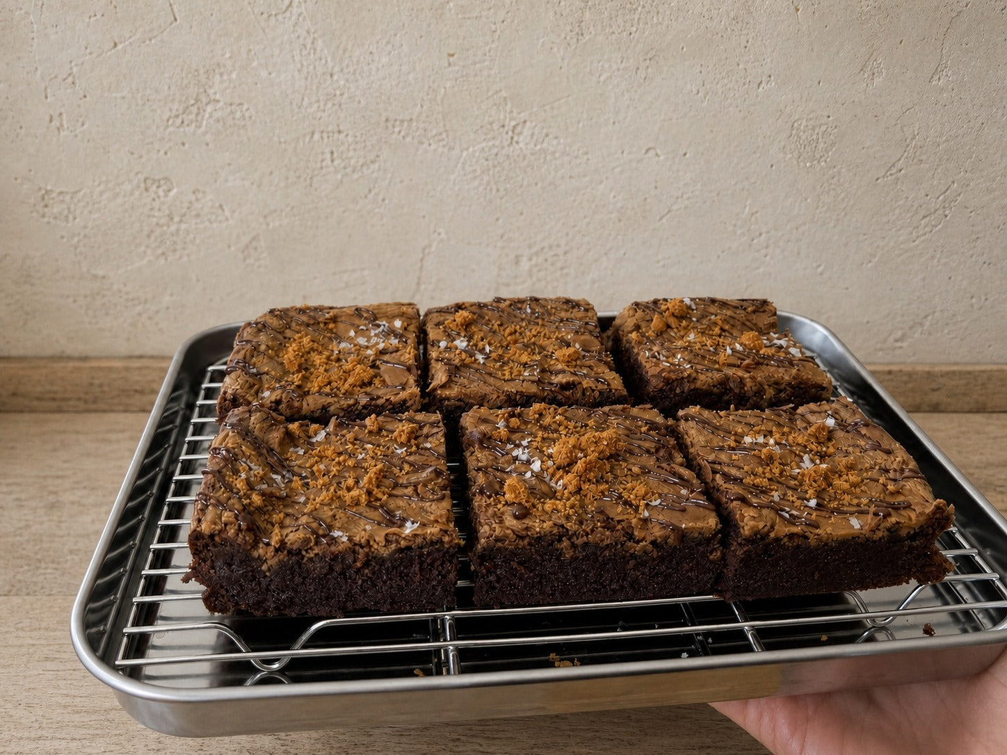 Six Miso Biscoff brownies arranged on a stainless-steel tray.
